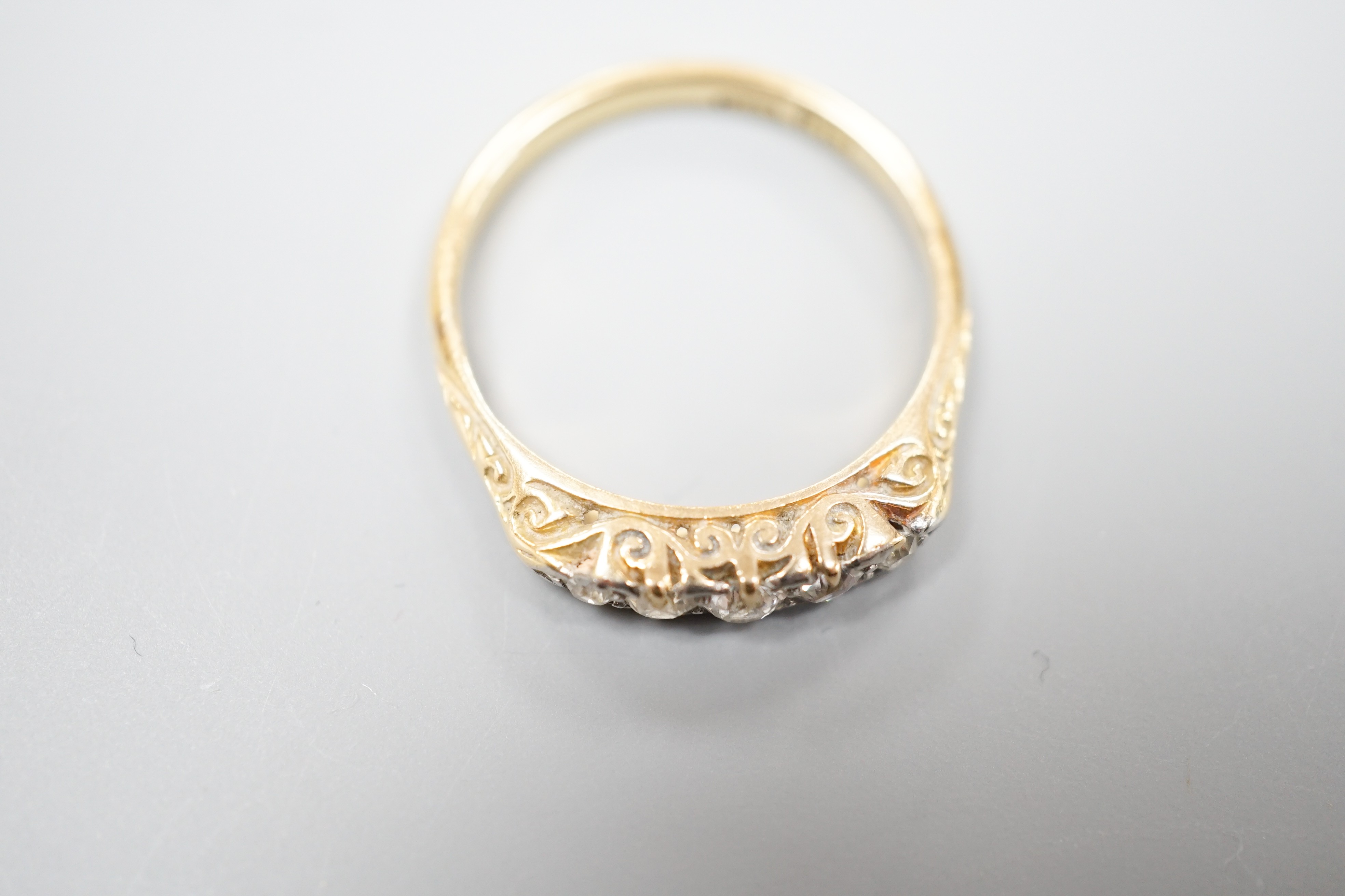 An 18ct and graduated five stone diamond set half hoop ring, size O, gross weight 3 grams.